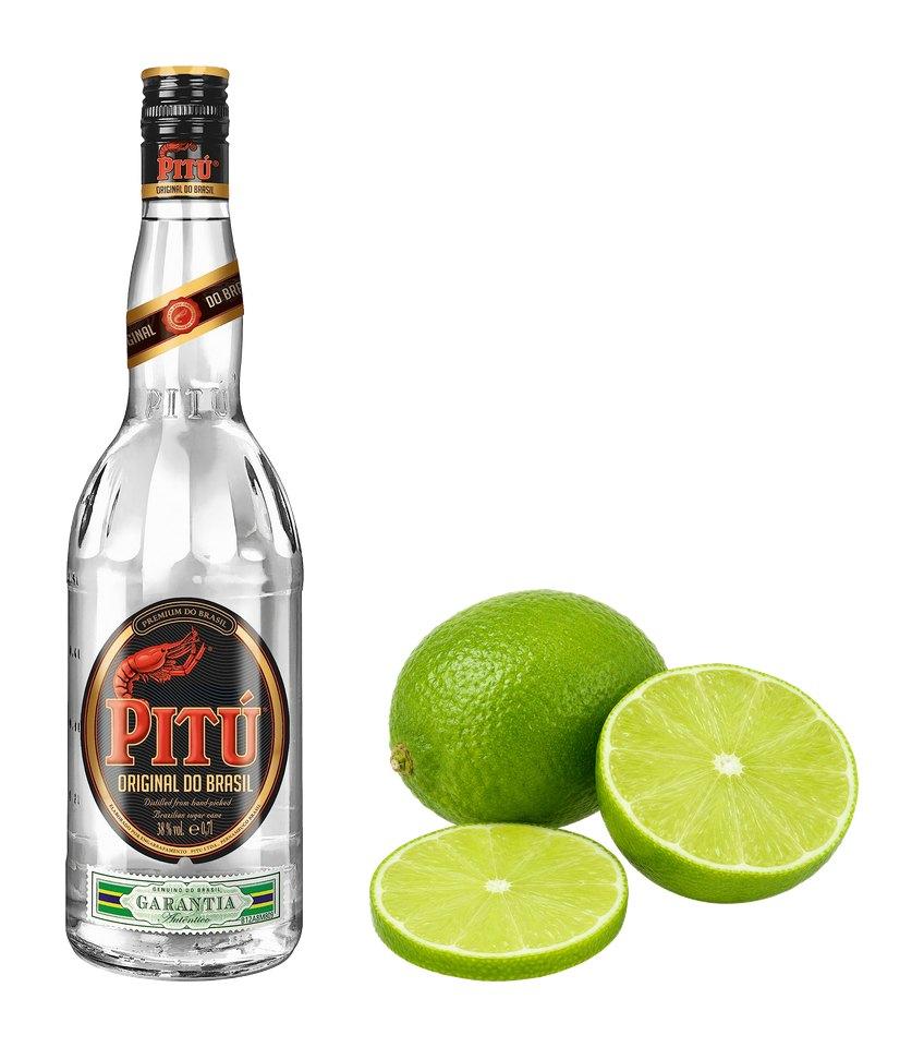 Fľaša brazílskej cachaçy Pitú a limetka, celá aj rozkrojená.